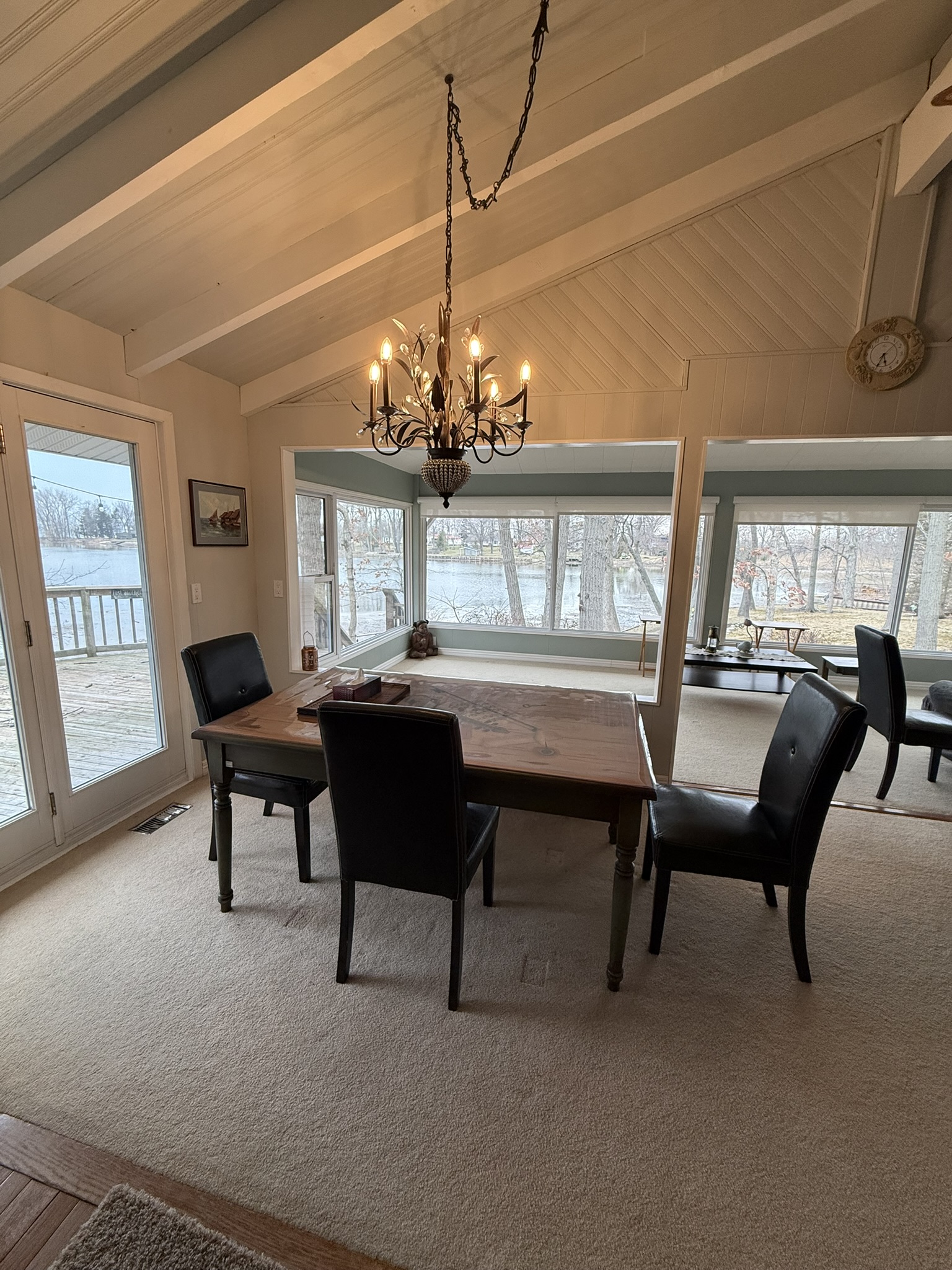 Dining area with chandelier and water views through large windows