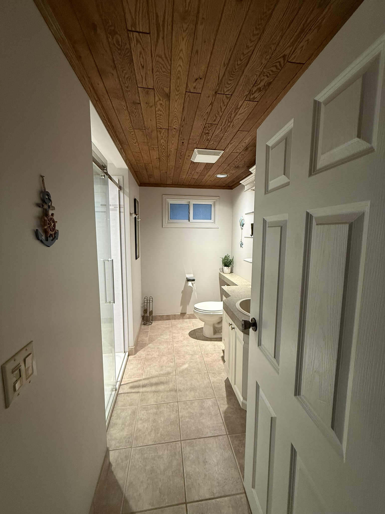 Second bathroom with glass shower and wooden ceiling